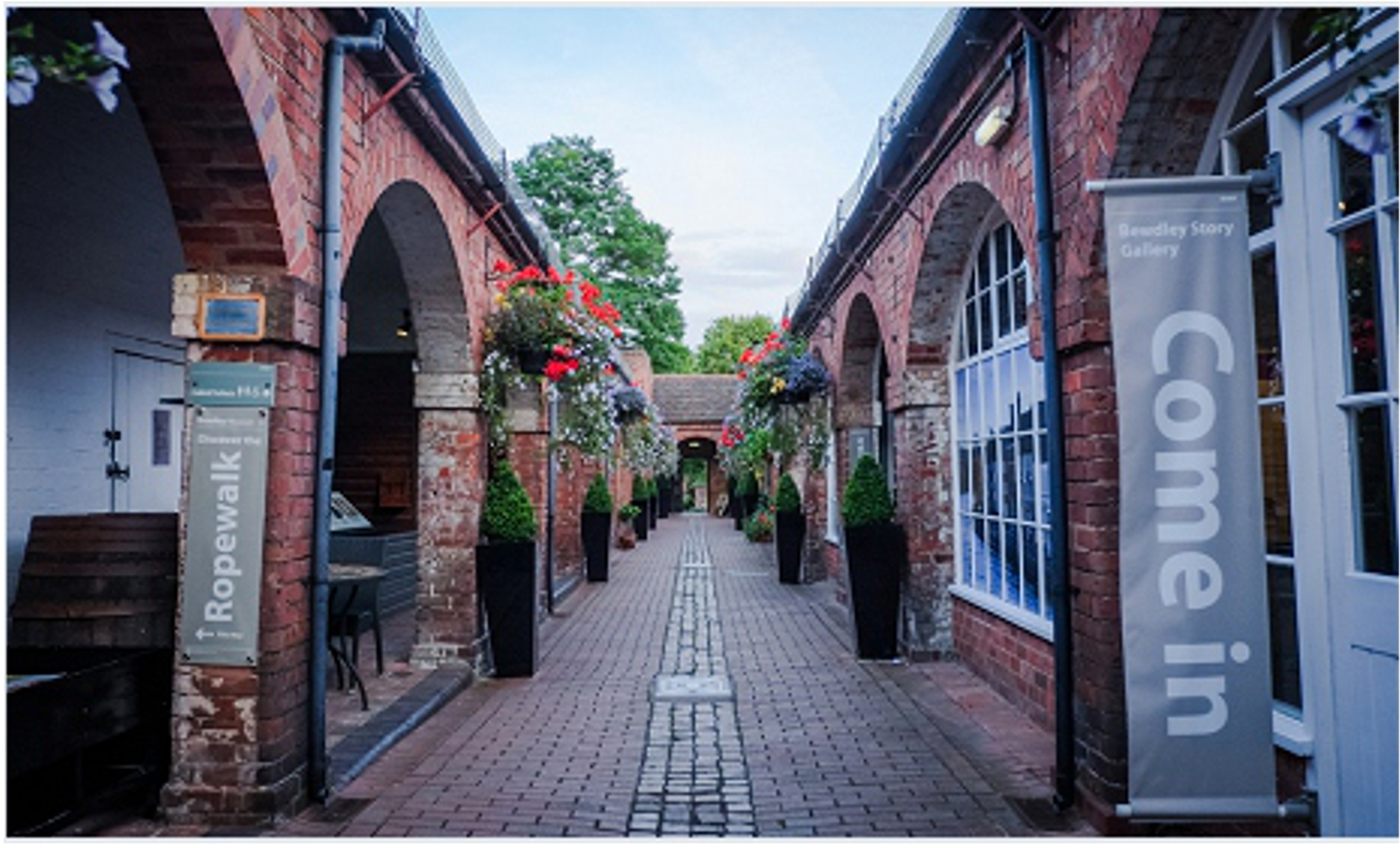 View down the shambles, cobbled path with brick arched doors either side